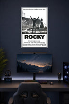 Rocky Balboa Triumphant in a gaming desk setup above a monitor.