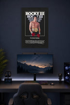 Rocky III Sylvester Stallone in a gaming desk setup above a monitor.