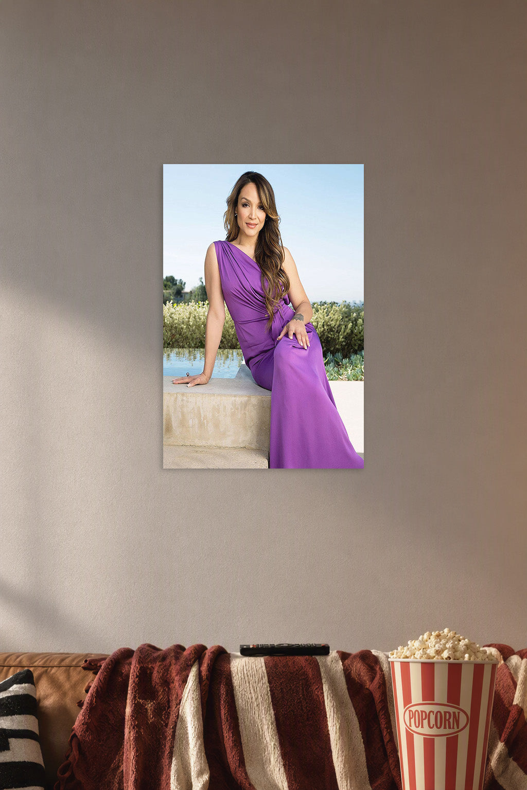 Rocsi Diaz in a cozy movie room above a brown sofa with popcorn.