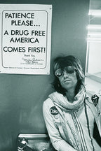 Keith Richards poster featuring a monochrome candid portrait of the musician in sunglasses, scarf, and patched jacket by a wall sign.