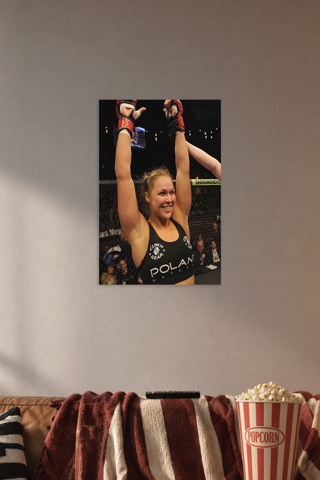 Ronda Rousey in a cozy movie room above a brown sofa with popcorn.