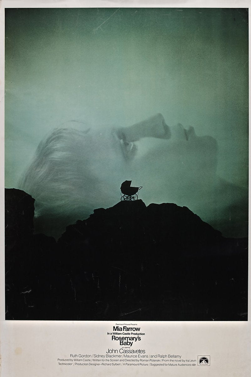Rosemary's Baby poster features a pale woman’s profile above a black baby carriage on jagged rocks in a misty green sky.