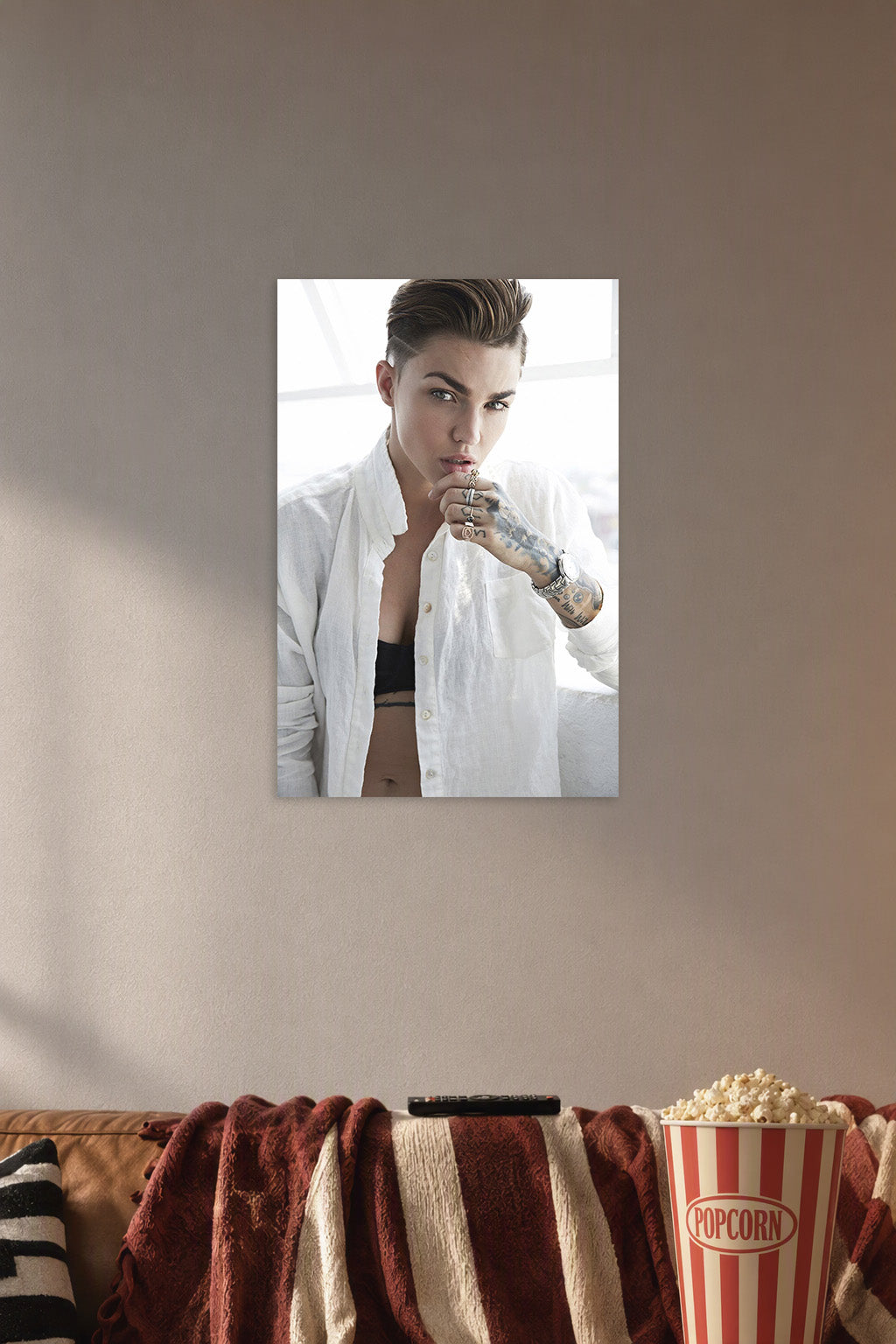 Ruby Rose in a cozy movie room above a brown sofa with popcorn.