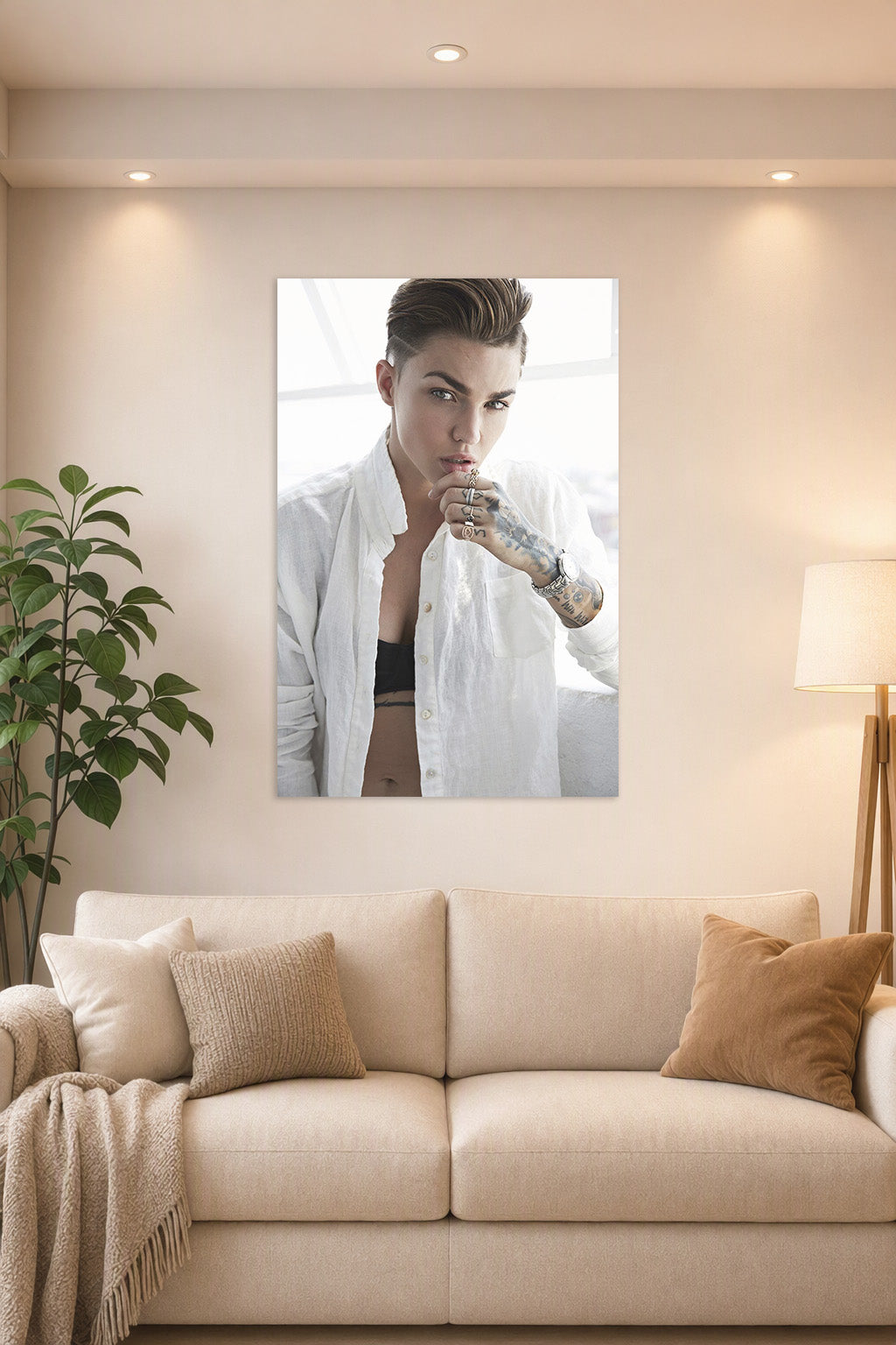 Ruby Rose in a bright living room above a beige sofa.