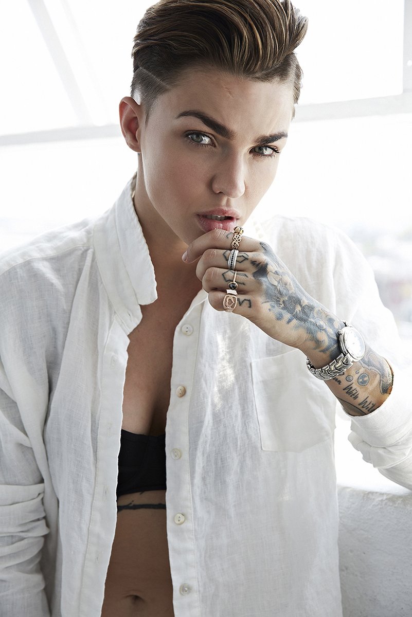 Ruby Rose wall art print features a close portrait in a white shirt, with tattooed hand, rings, and silver watch.