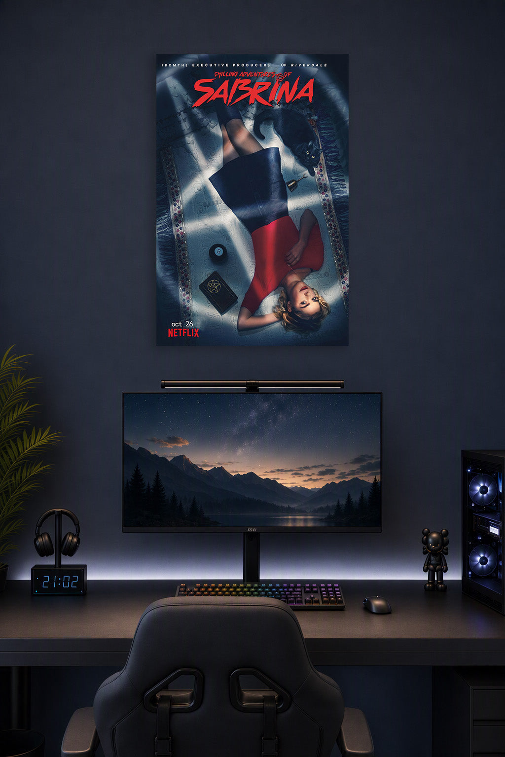 Sabrina Spellman Chilling Adventures in a gaming desk setup above a monitor.