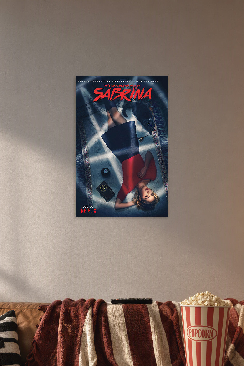 Sabrina Spellman Chilling Adventures in a cozy movie room above a brown sofa with popcorn.