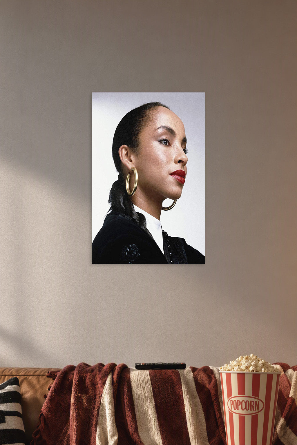 Sade Adu in a cozy movie room above a brown sofa with popcorn.