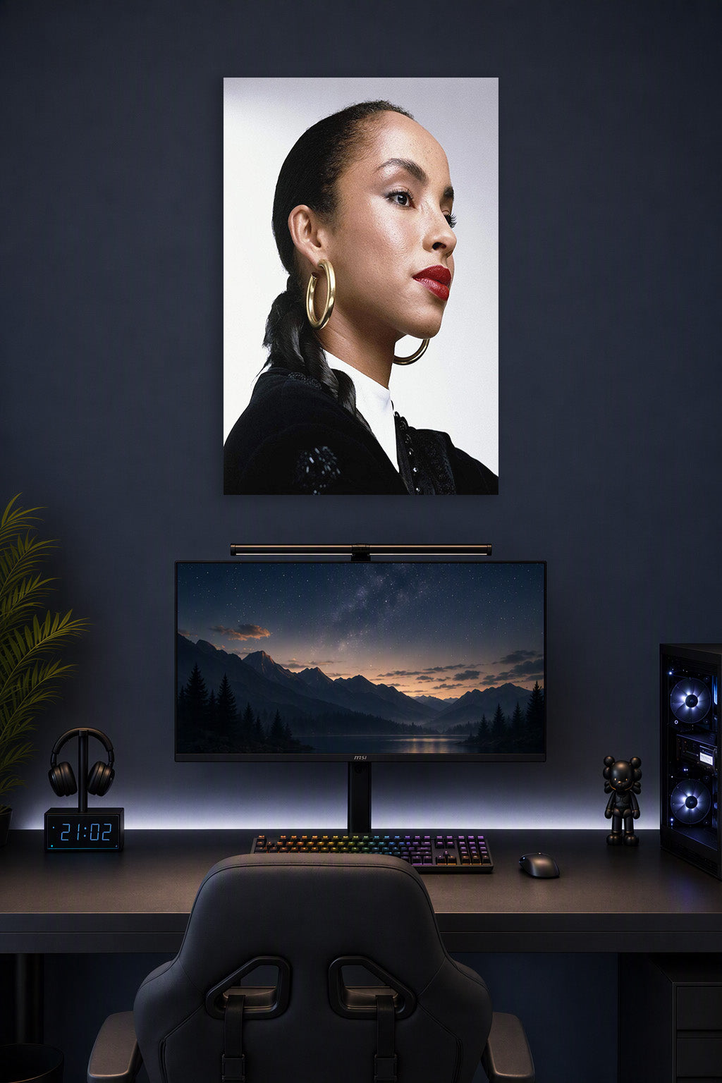Sade Adu in a gaming desk setup above a monitor.