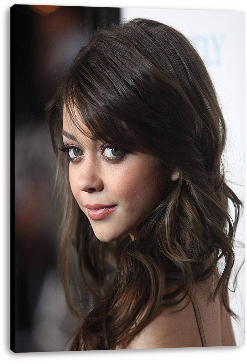 Sarah Hyland canvas wall art print featuring her close-up portrait, wavy brown hair, and a softly blurred dark and white backdrop.