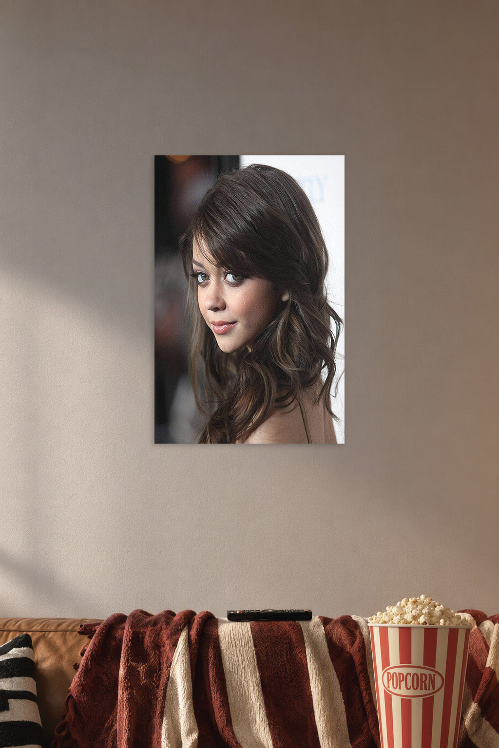 Sarah Hyland in a cozy movie room above a brown sofa with popcorn.