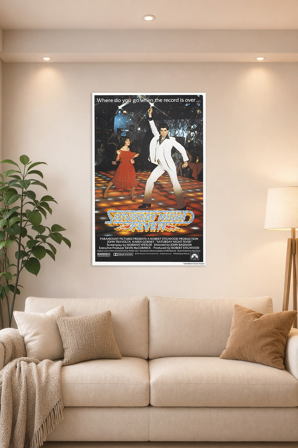 Saturday Night Fever John Travolta in a bright living room above a beige sofa.