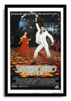 Saturday Night Fever movie poster wall art print in a black frame, with disco dancers under starry lights and the metallic gold-and-blue title.