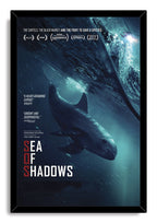Sea of Shadows framed wall art print depicts a vaquita in a deep blue ocean below waves and a distant helicopter.