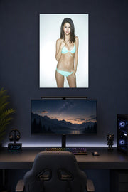 Selena Gomez in a gaming desk setup above a monitor.