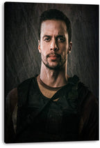Tactical man canvas wall art print, presented with visible wrapped edges, portrays a serious bearded figure in dark gear.