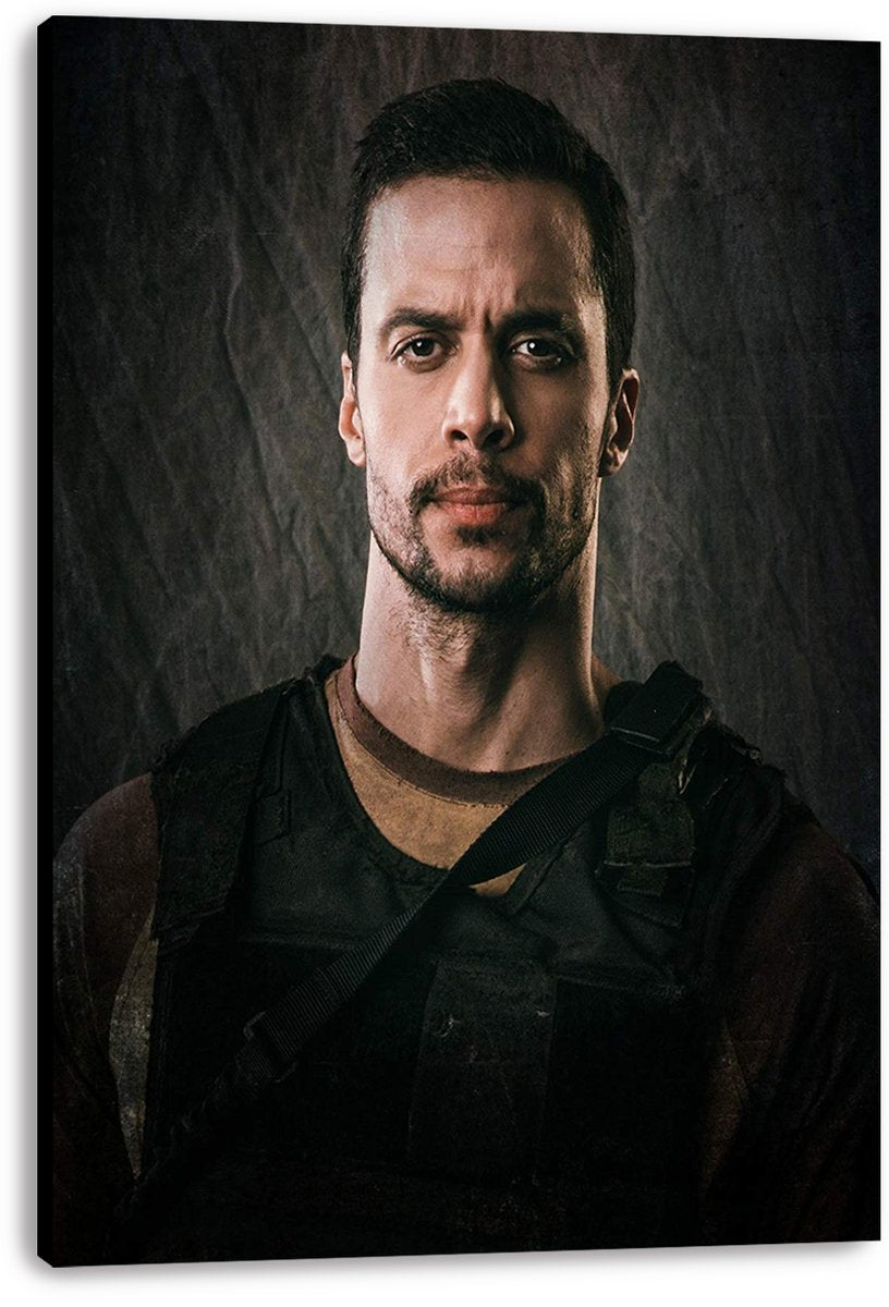 Tactical man canvas wall art print, presented with visible wrapped edges, portrays a serious bearded figure in dark gear.