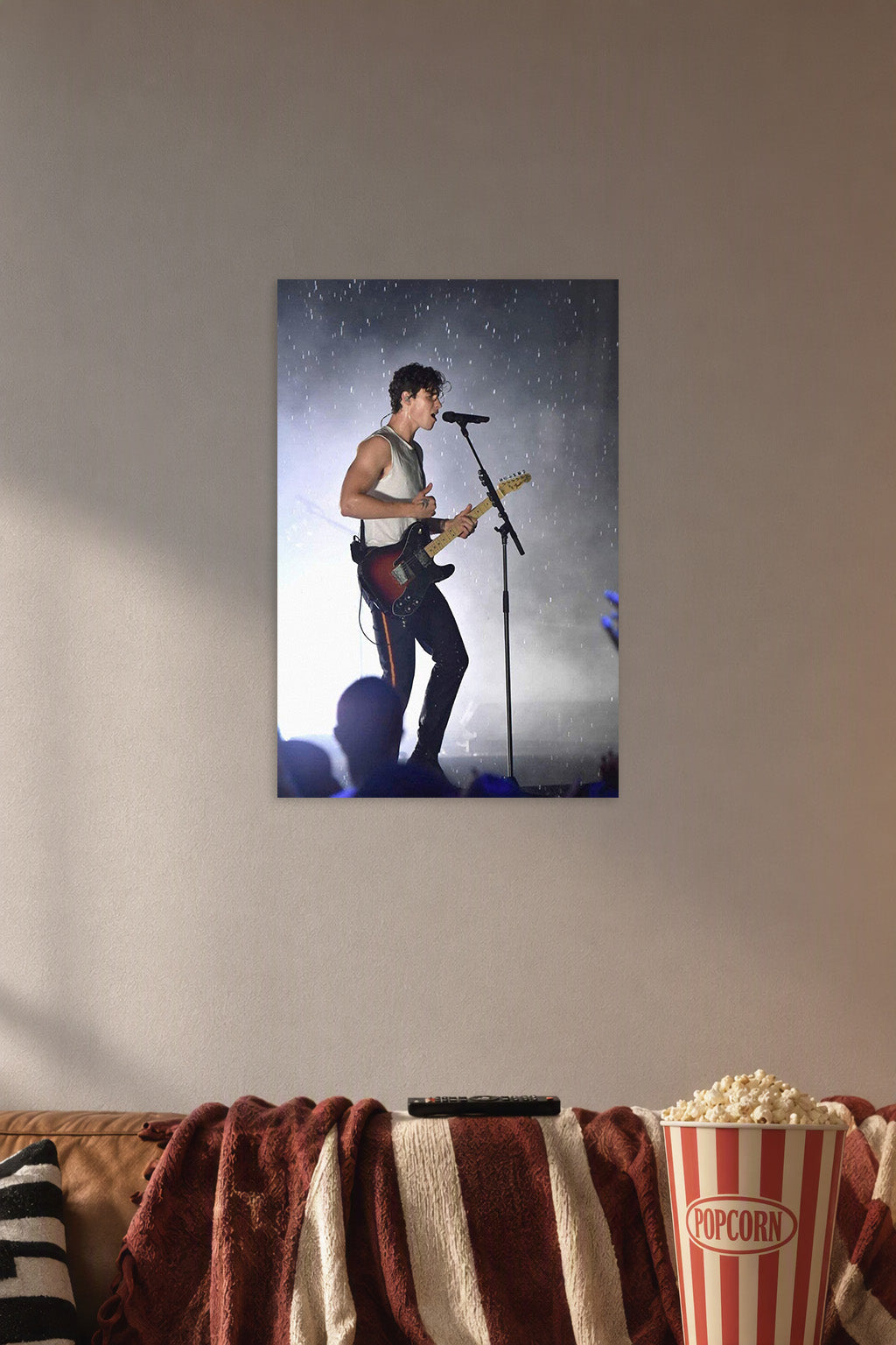 Shawn Mendes in a cozy movie room above a brown sofa with popcorn.