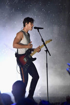 Shawn Mendes poster captures the singer performing in rain, singing at a microphone with a sunburst electric guitar.