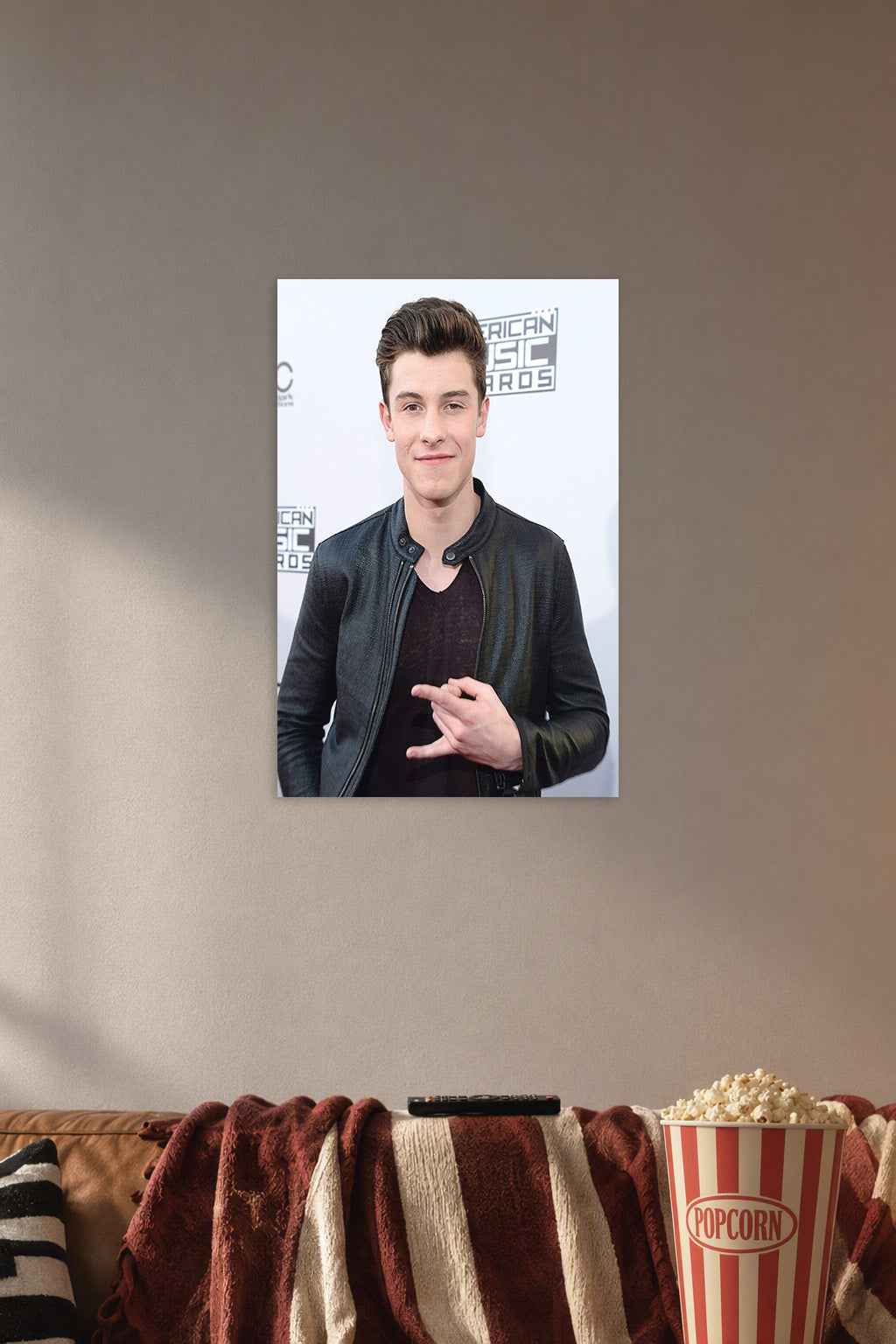 Shawn Mendes in a cozy movie room above a brown sofa with popcorn.