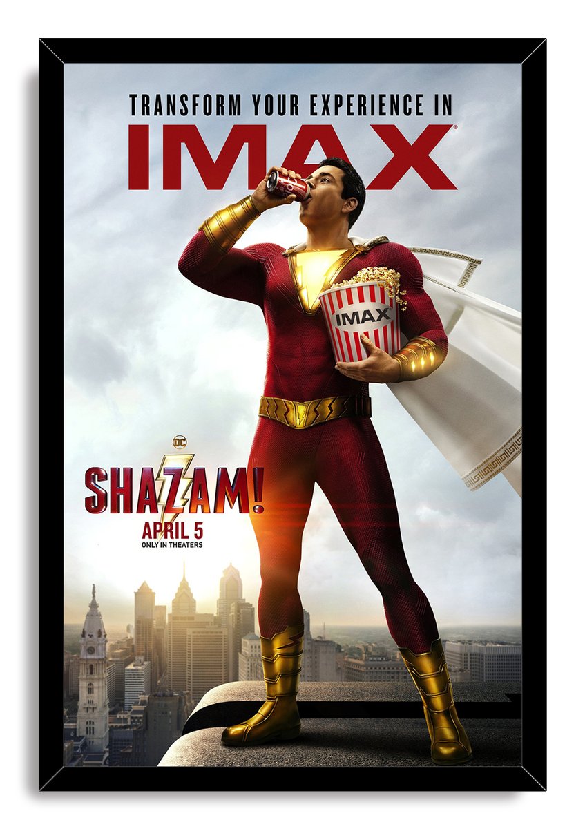 Shazam framed wall art print features the red-suited hero holding popcorn and a drink, with a cloudy city backdrop and black frame.