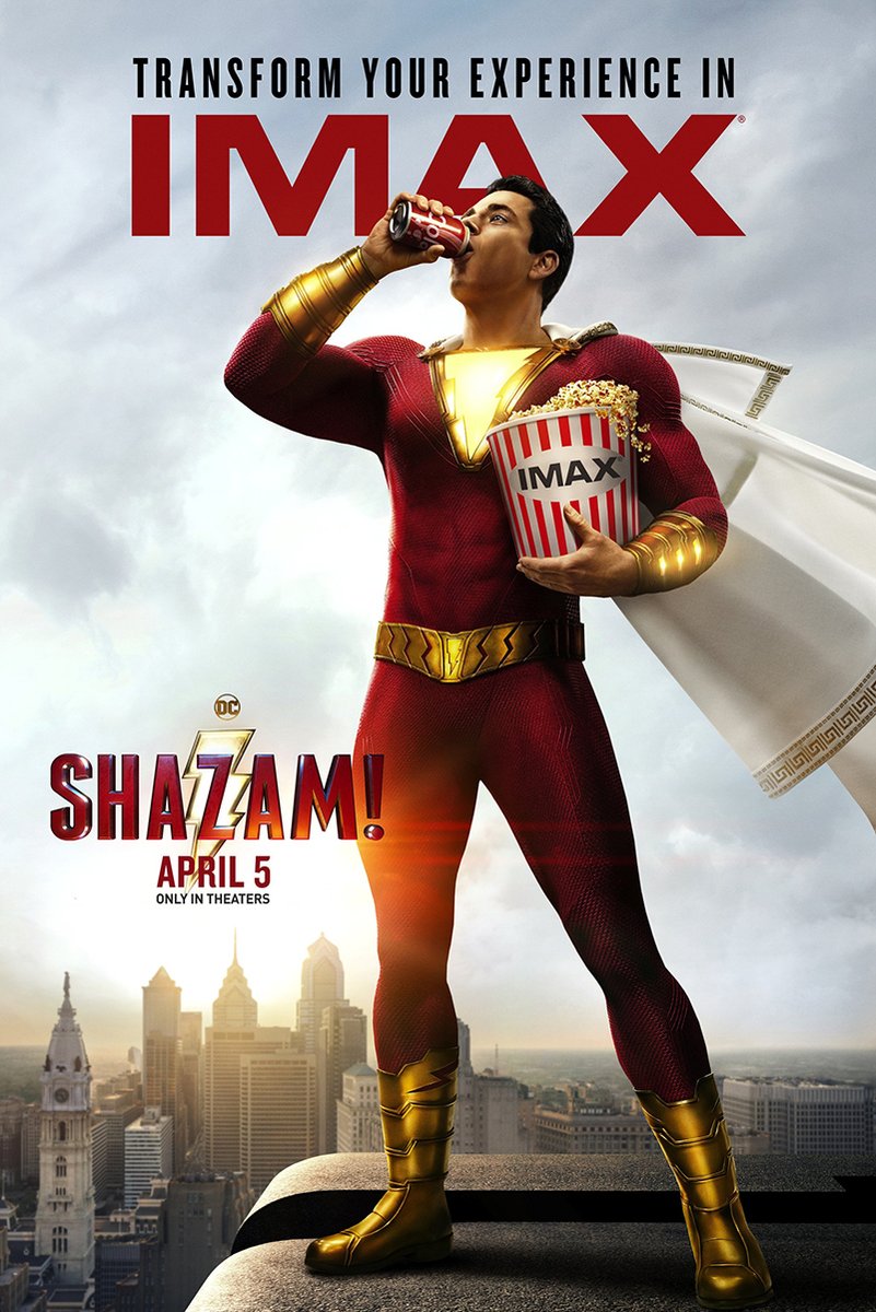 Shazam movie poster wall art print depicts the red-suited hero drinking from a can and holding popcorn above a city skyline.