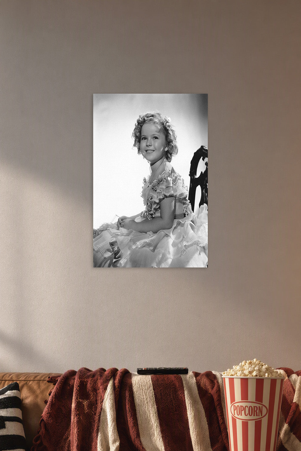 Shirley Temple in a cozy movie room above a brown sofa with popcorn.