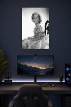 Shirley Temple in a gaming desk setup above a monitor.