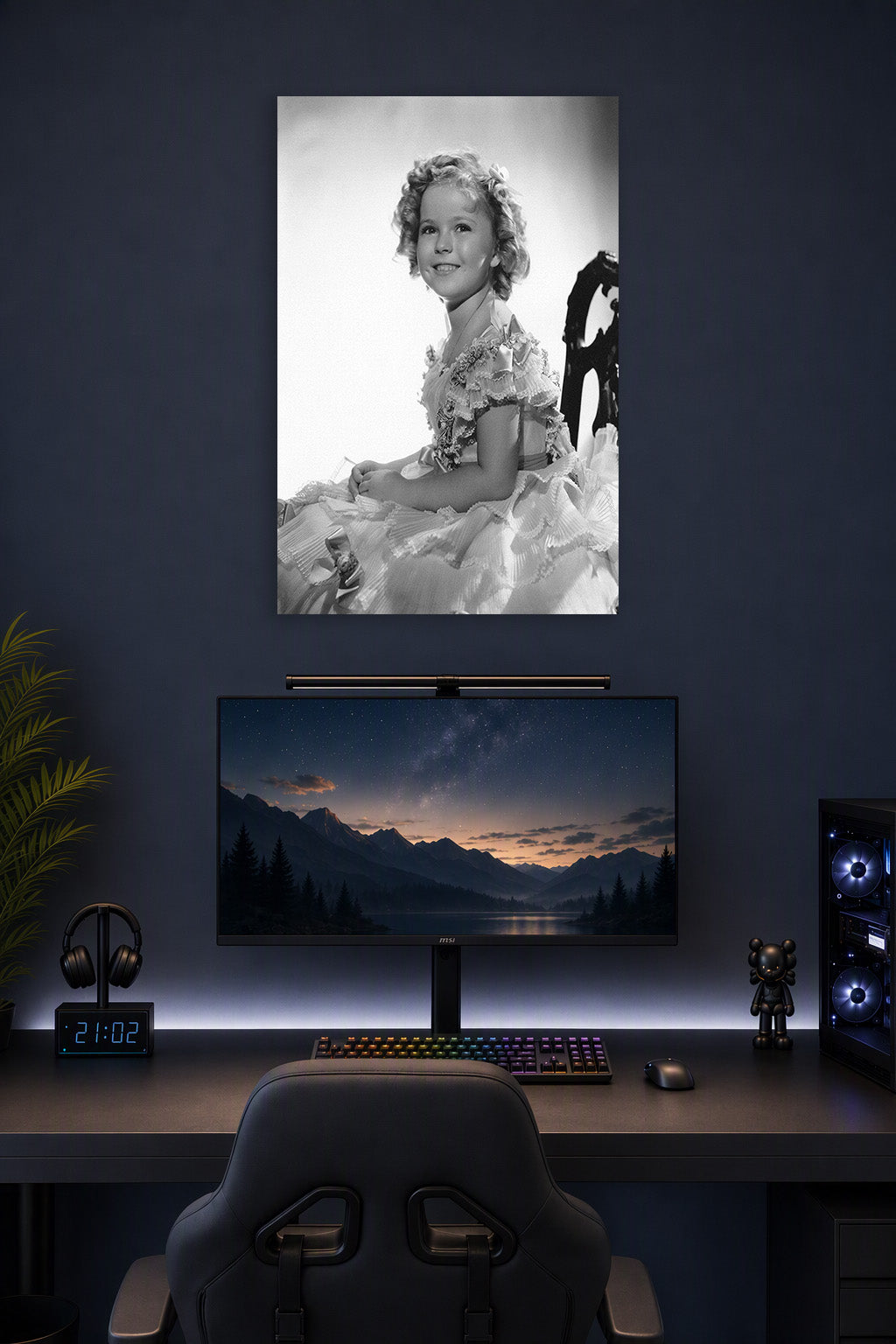 Shirley Temple in a gaming desk setup above a monitor.