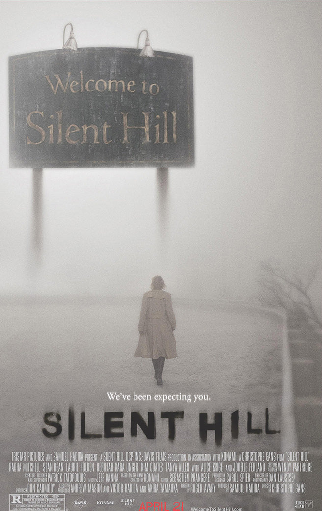 Silent Hill poster wall art print with a lone woman walking through dense fog beneath a Welcome to Silent Hill sign.
