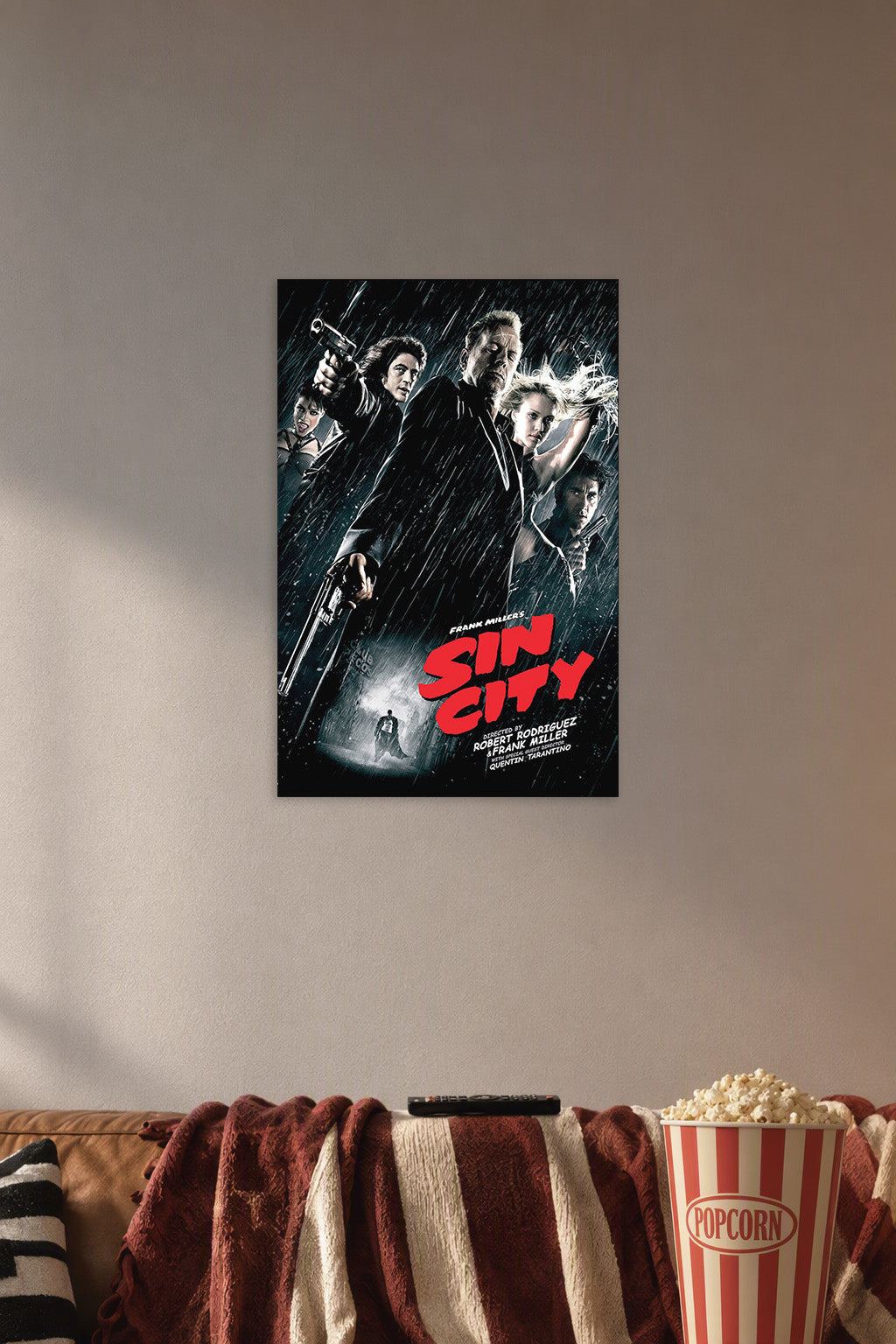 Sin City Movie Poster in a cozy movie room above a brown sofa with popcorn.