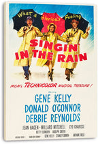 Singin' in the Rain movie poster canvas print featuring three performers in yellow raincoats, umbrellas, and bold red title text.