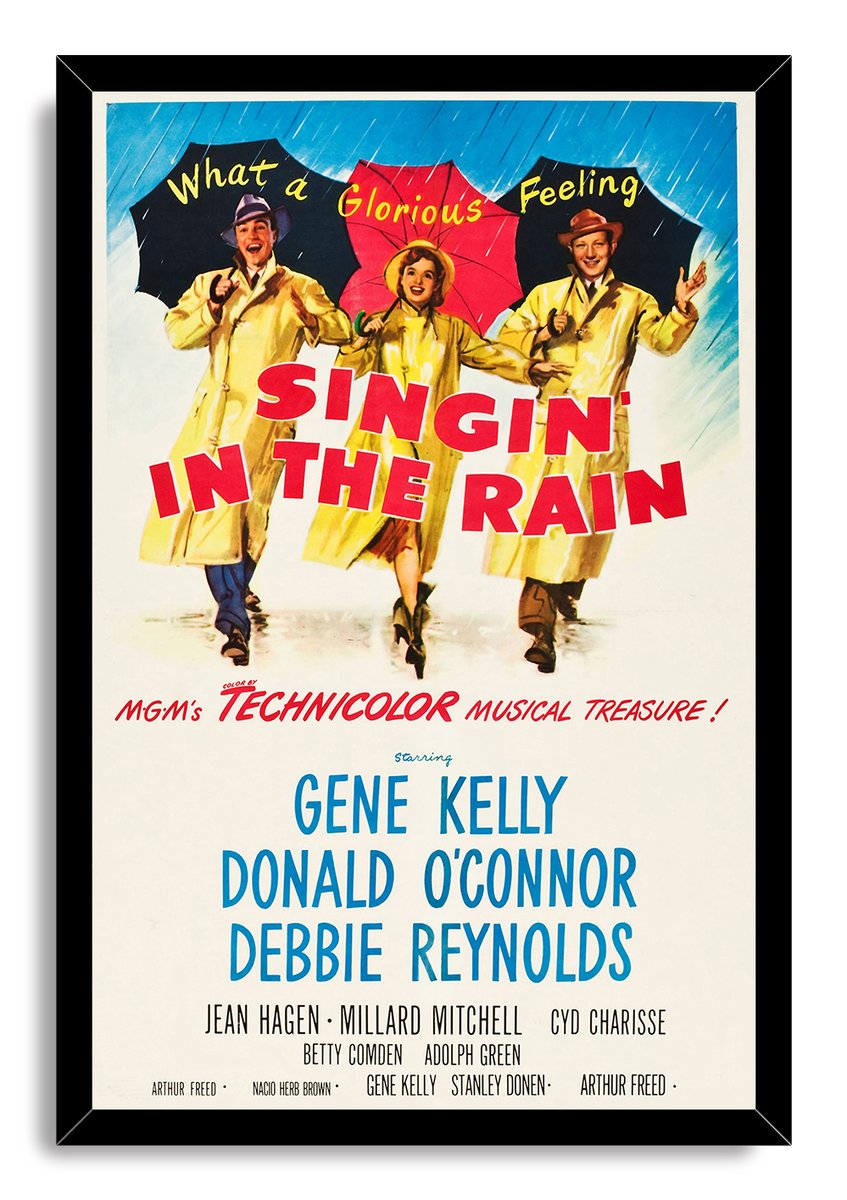 Singin' in the Rain framed wall art print with black border, rainy blue sky, yellow raincoats, umbrellas, and cast names.