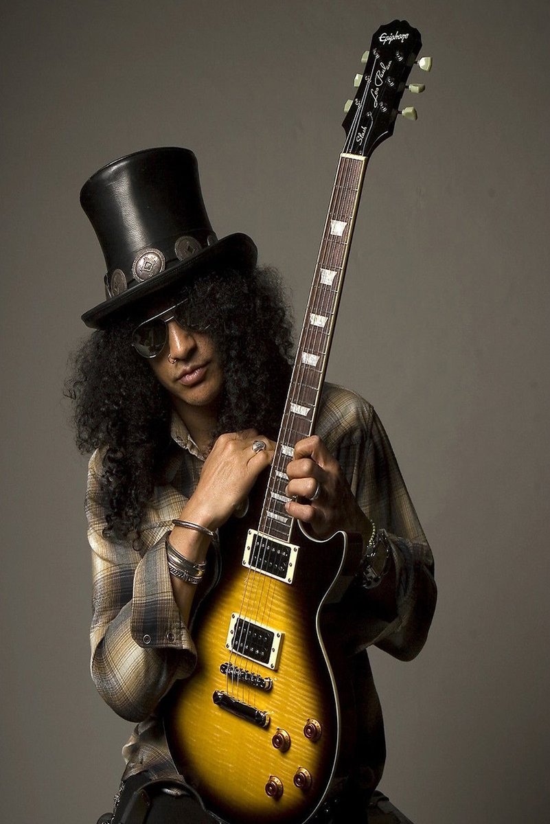 Slash wall art print featuring the guitarist in a black top hat and sunglasses holding a sunburst electric guitar against gray.