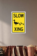 Slow Duck Crossing Sign in a cozy movie room above a brown sofa with popcorn.