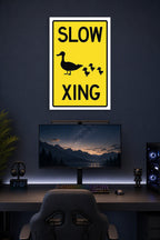 Slow Duck Crossing Sign in a gaming desk setup above a monitor.