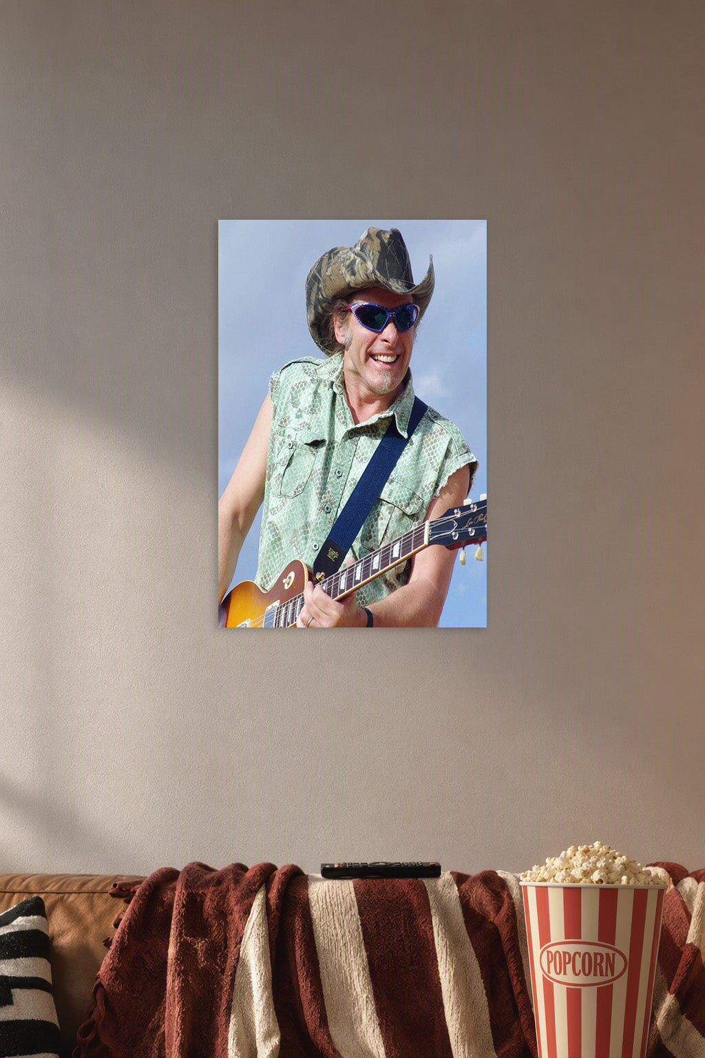 Smiling Guitarist in Cowboy Hat in a cozy movie room above a brown sofa with popcorn.