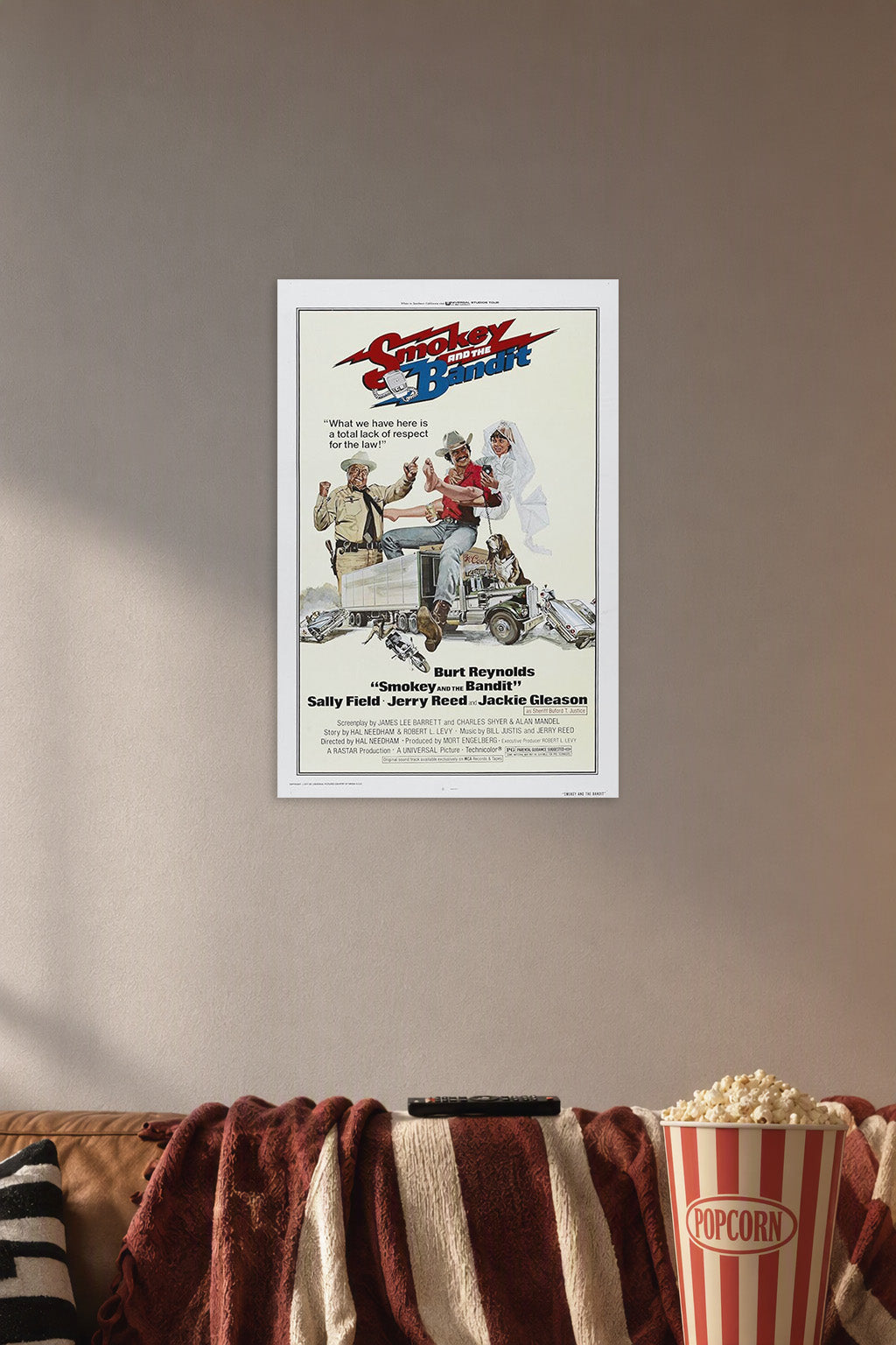Smokey and The Bandit (1977) Movie Poster in a cozy movie room above a brown sofa with popcorn.
