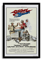 Smokey and the Bandit framed wall art print in a black frame, with illustrated characters, a truck, dog, motorcycles, and wrecked cars.