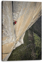 Rock climber canvas wall art print features a red-clad climber on a towering beige rock face over dense woodland.