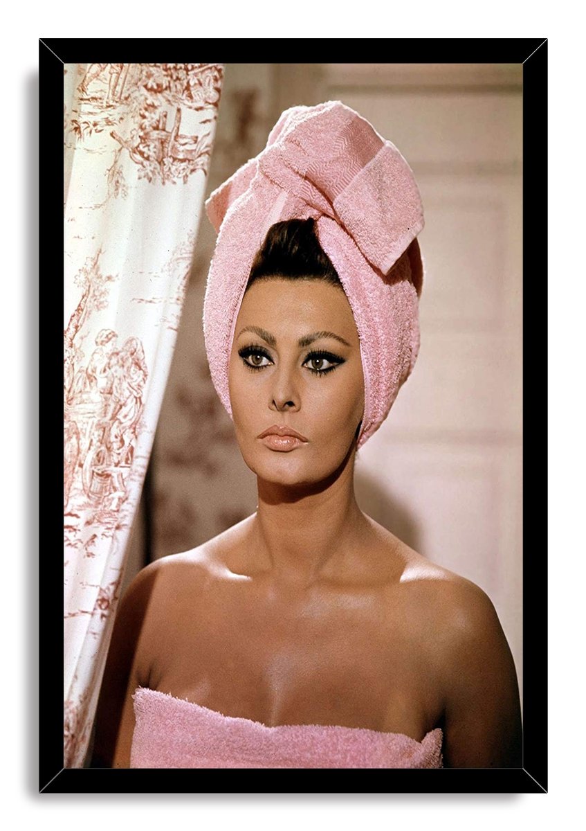 Sophia Loren framed wall art print features her poised in pink towels beside an ornate patterned curtain.