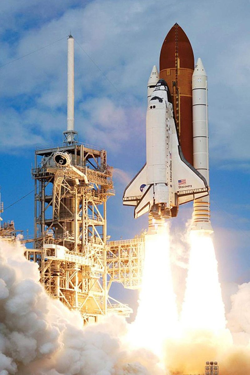 Space Shuttle Discovery poster captures the white orbiter lifting beside its launch tower, with blazing engines and dense smoke under a blue sky.