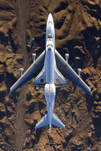 Space Shuttle Endeavour poster presents a top-down view of the white orbiter riding a 747 over rugged brown desert terrain.