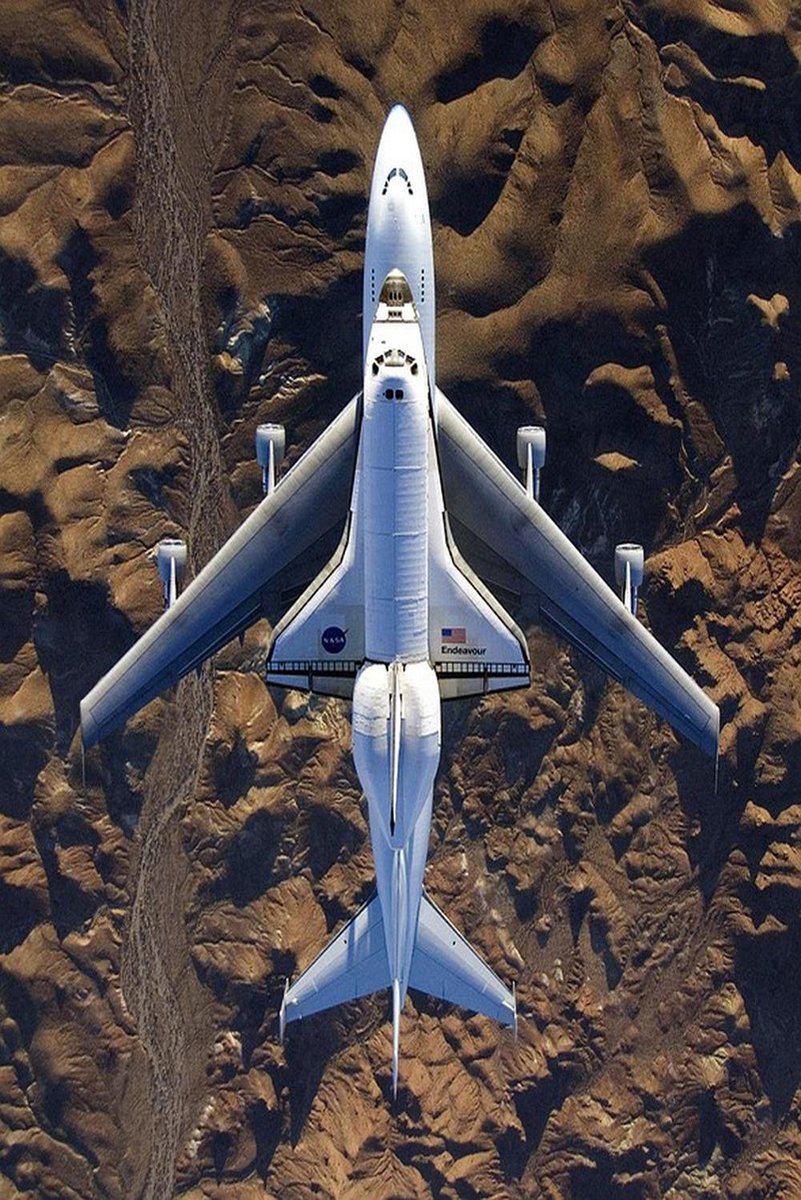Space Shuttle Endeavour poster presents a top-down view of the white orbiter riding a 747 over rugged brown desert terrain.
