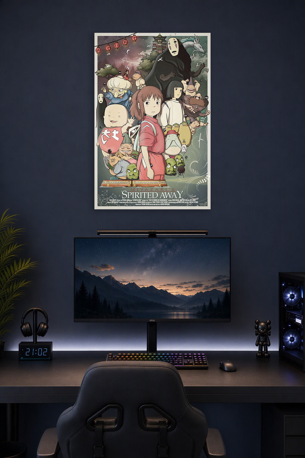 Spirited Away in a gaming desk setup above a monitor.