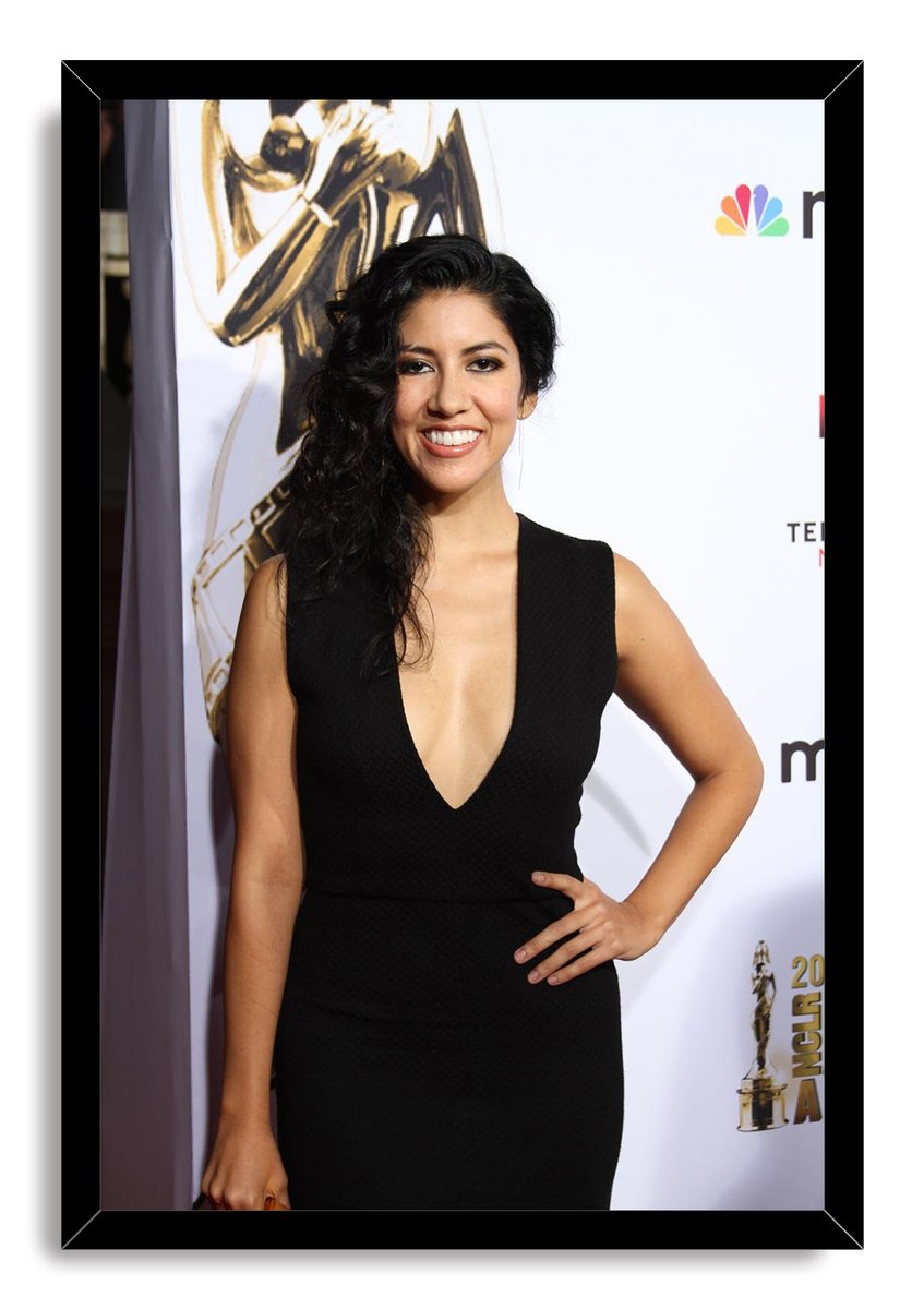 Stephanie Beatriz framed wall art print presents her smiling in a black dress at an awards-event backdrop, enclosed by a glossy black frame.
