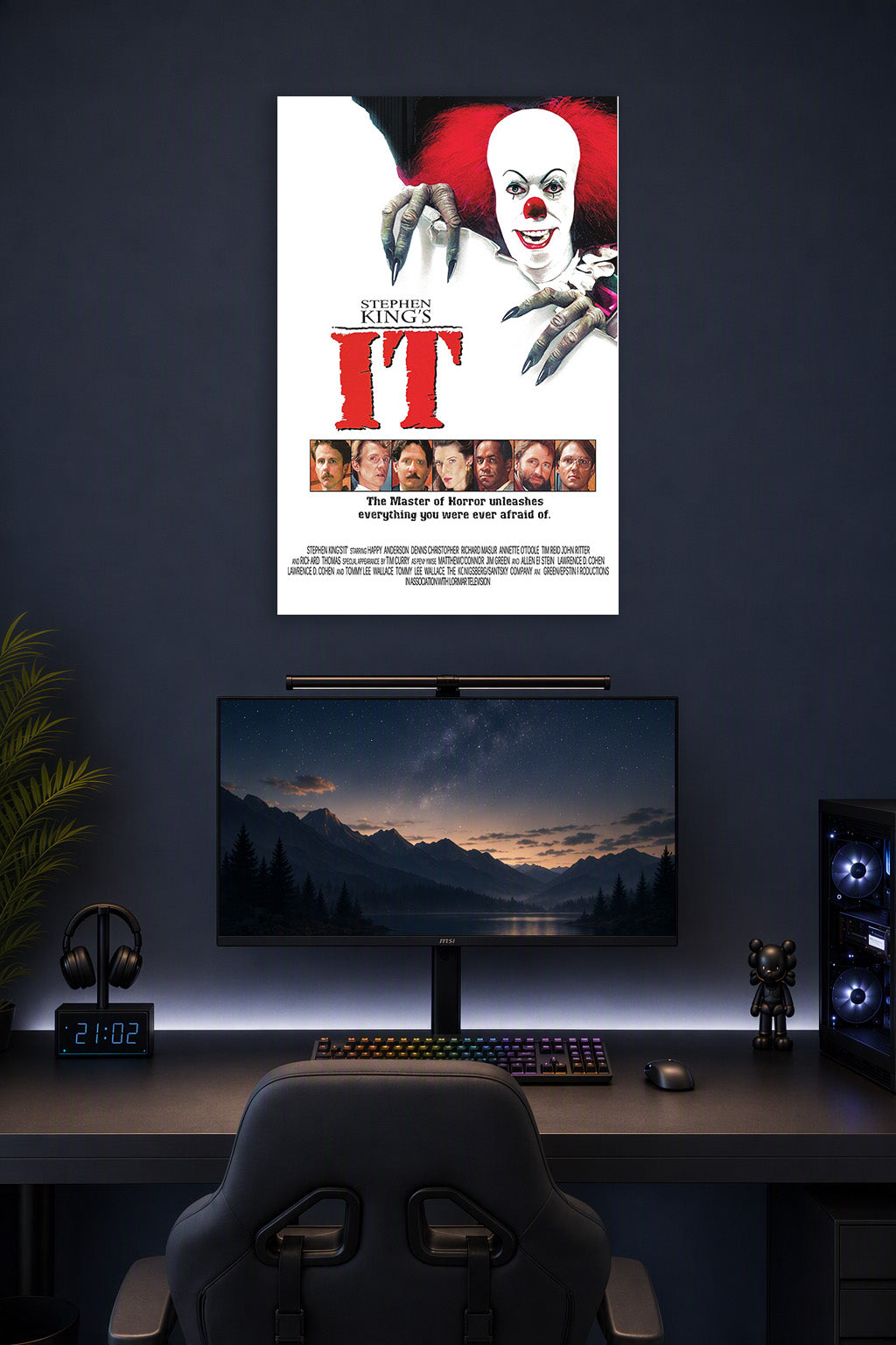 Stephen King's IT Pennywise in a gaming desk setup above a monitor.