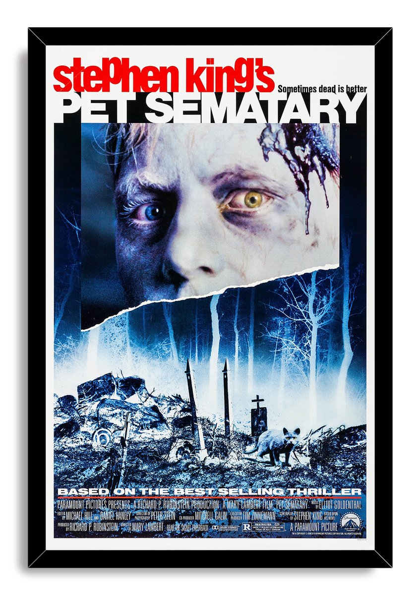Pet Sematary framed wall art print with a black border, eerie face, moonlit blue cemetery, tombstones, and cat.