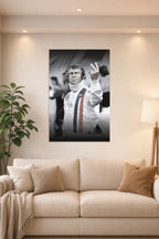 Steve McQueen in a bright living room above a beige sofa.