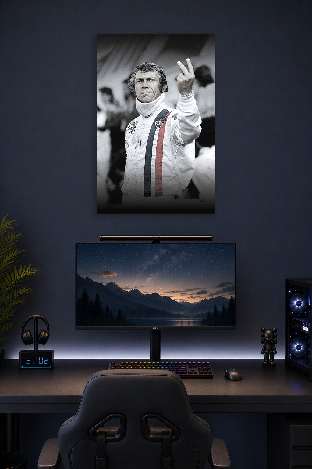 Steve McQueen in a gaming desk setup above a monitor.